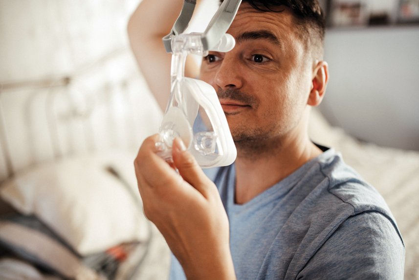 Man putting on CPAP mask on