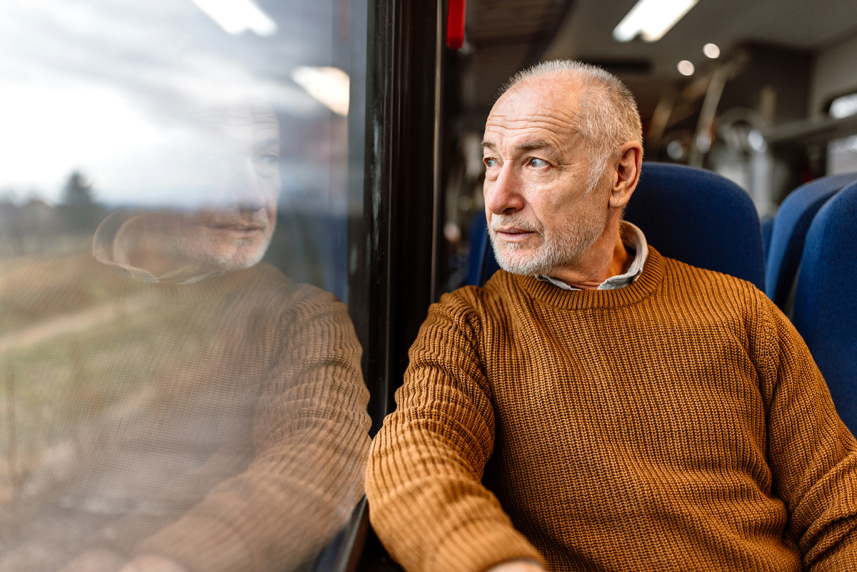 Man looking out the window on a train