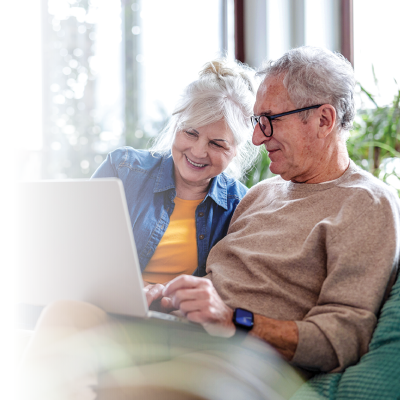 Man and woman sitting in the couch in front of a laptop