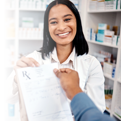 A pharmacist smiling while taking a prescription from a customer