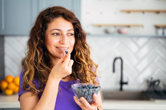 Woman eating blueberries.