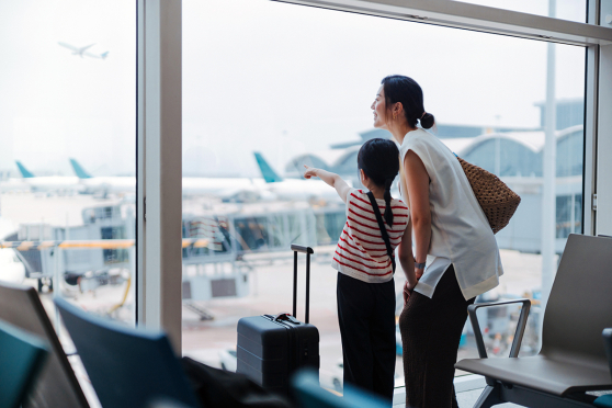 Mother and daughter watching planes take off at the airport.