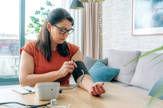 Woman taking blood pressure at home