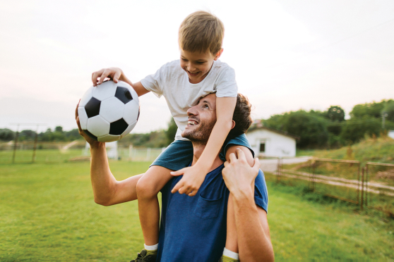 Son and father playing soccer