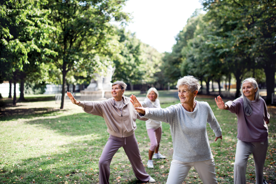 A group of people doing tai chi in the park