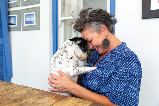 A woman cuddles with a puppy