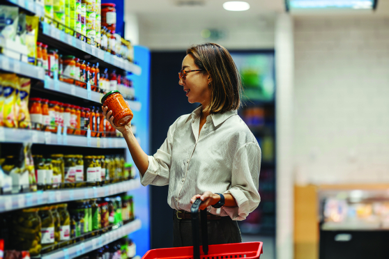 Woman looking at jar in grocery store